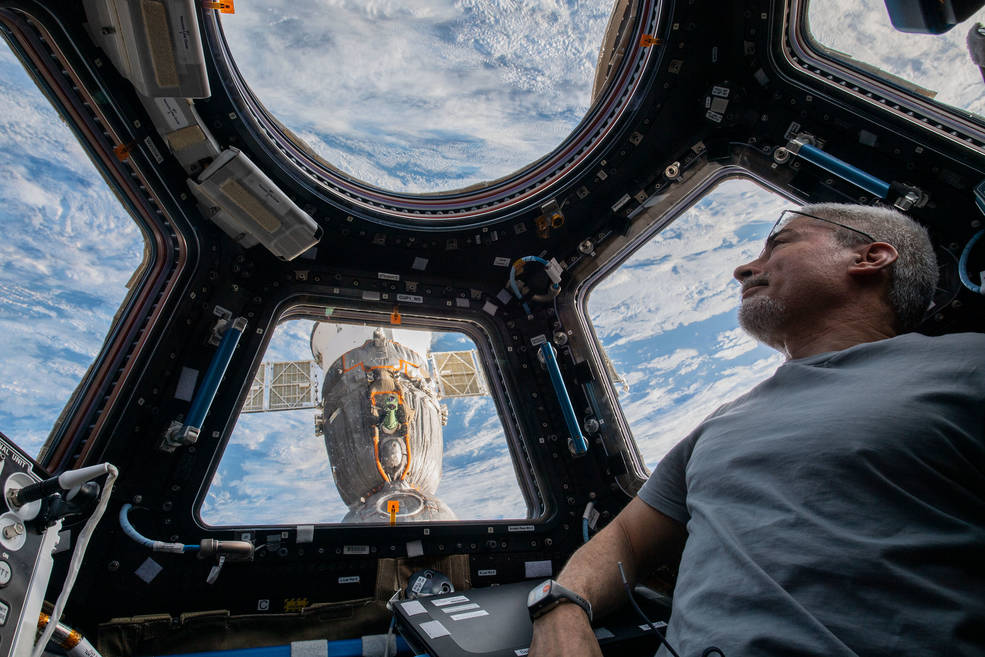 Mark Vande Hei in the internation space station sitting in front of window